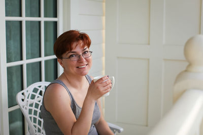 Portrait of a smiling young woman drinking glass