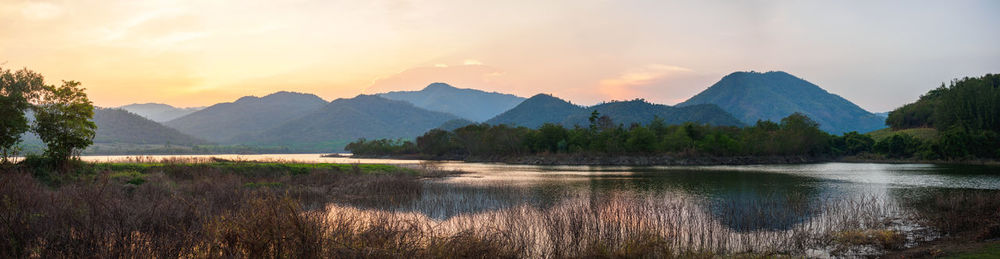 Scenic view of lake and mountains against sky during sunset