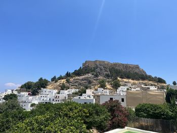 Buildings in town against clear blue sky