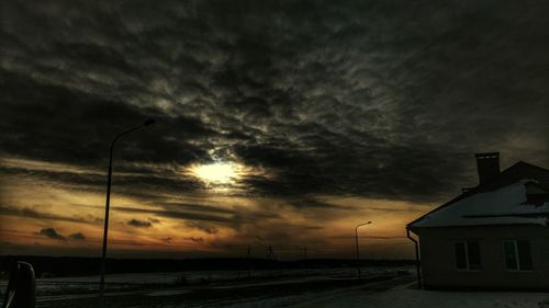 Silhouette of electricity pylon against storm clouds