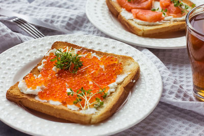 Sandwiches or tapas of bread red caviar and red fish with micro greens, seafood luxury delicacy food