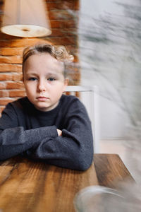 Portrait of boy sitting on table