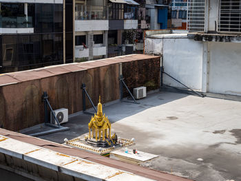 Local scene of a small golden buddhist temple on a rooftop in bangkok, thailand.