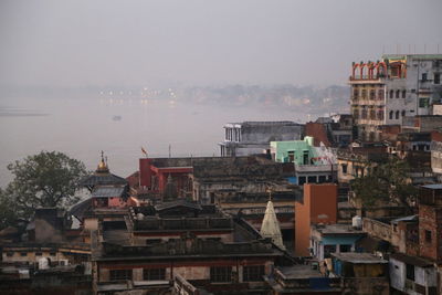 Houses by sea against sky in town