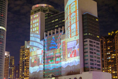 Low angle view of illuminated buildings against sky at night