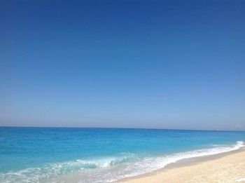 Scenic view of beach against blue sky