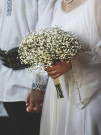 Close-up of bride holding flower bouquet