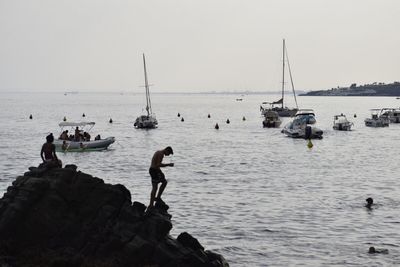 People on beach against clear sky