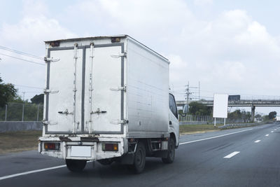 Truck on road against sky in city