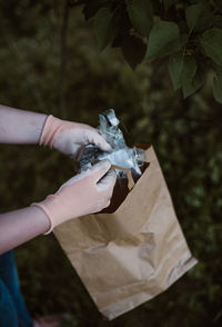 Cropped hand holding paper bag