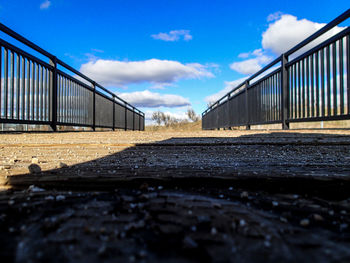 Surface level of railroad track against cloudy sky