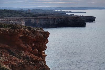 Rock formation on sea against sky