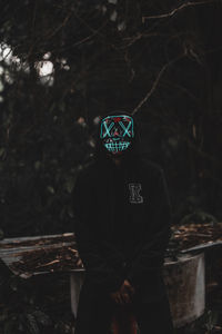 Man standing by tree in forest