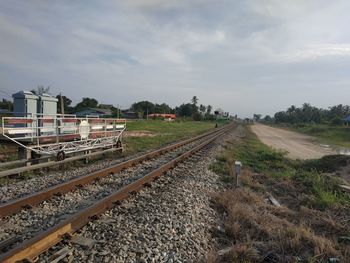 Railroad tracks on field against sky