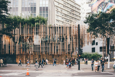 People on street against buildings in city