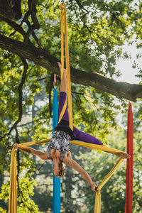 Young woman doing acrobatic activity with fabric