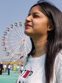 Portrait of woman with carousel in amusement park