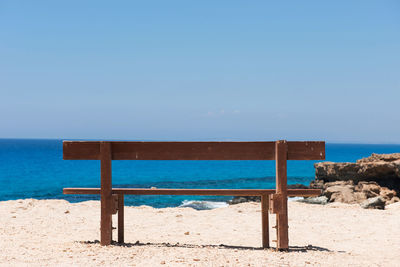 Lifeguard hut on beach against clear blue sky