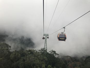 Low angle view of overhead cable car against sky