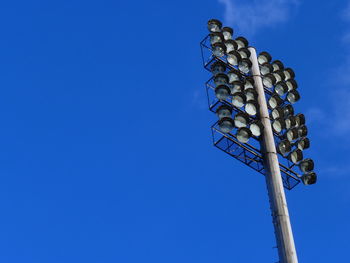 Low angle view of floodlight against blue sky