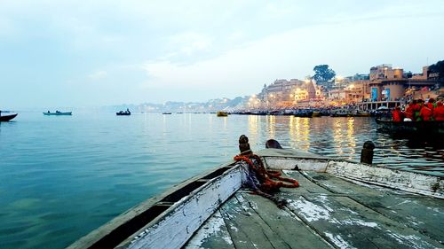 Boats moored on sea against sky in city