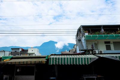 Low angle view of houses against cloudy sky