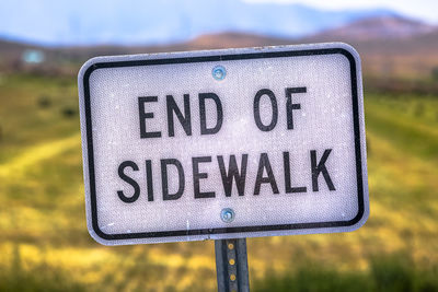 Close-up of road sign on field