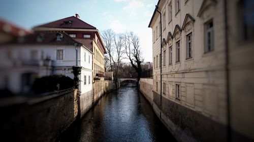 Canal amidst buildings against sky