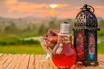 Close-up of dried food with lighting equipment on table during sunset