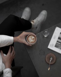 High angle view of hands holding drink