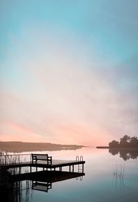 Silhouette pier on lake against sky during sunset