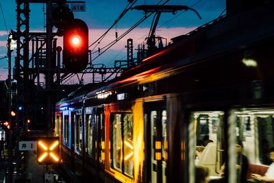 Train at illuminated city against sky at night