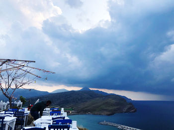 Scenic view of sea by mountains against sky