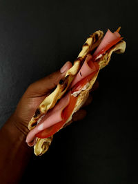 Cropped hand of woman holding food on table