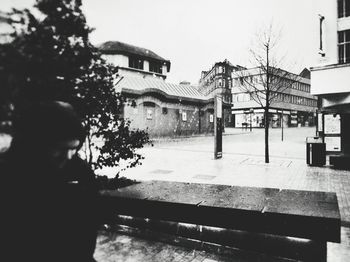 Man standing by building against clear sky