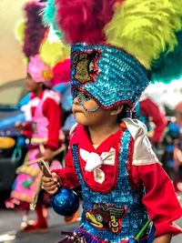 Boy wearing costume enjoying at carnival in city