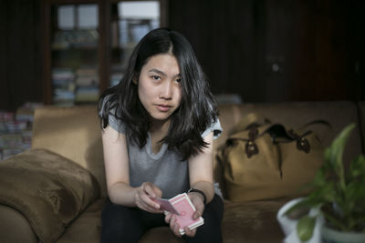 Close-up of young woman holding cards at home
