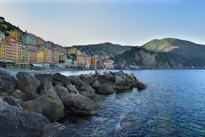 Scenic view of sea by buildings against sky
