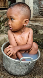 Midsection of shirtless boy sitting in water