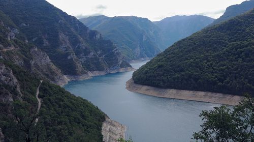 High angle view of river amidst mountains against sky