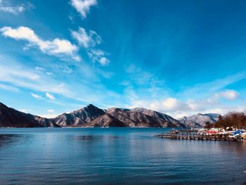 Scenic view of sea and mountains against blue sky