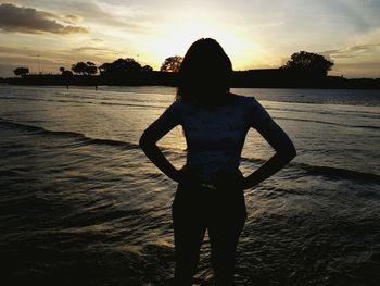 Rear view of silhouette man standing at beach