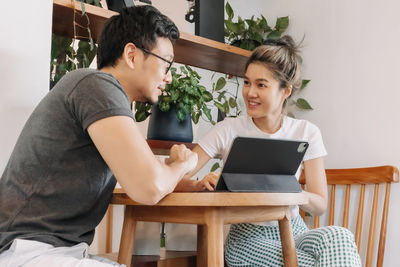 Friends using digital tablet while sitting at home
