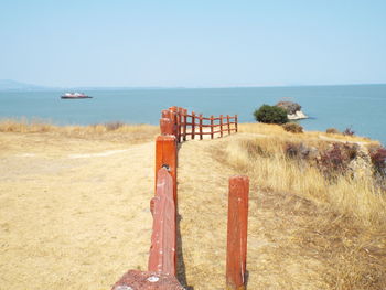 Wooden posts on beach against clear sky
