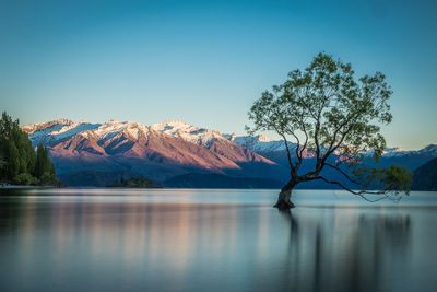 Scenic view of lake by mountains against sky