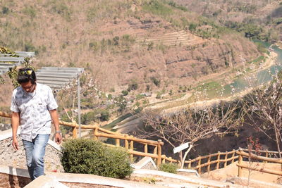 Man standing by plants against trees
