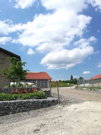 Houses by trees against sky