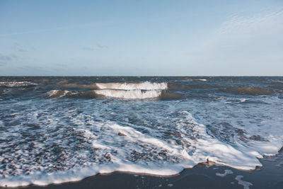 View of waves on shore against sky