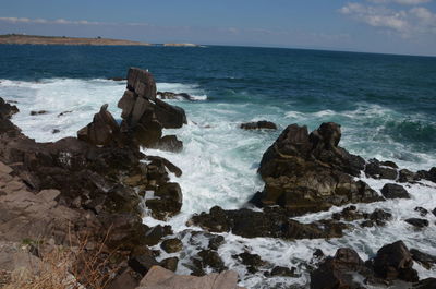 Scenic view of rocks in sea against sky