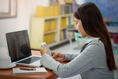 Side view of woman using mobile phone
